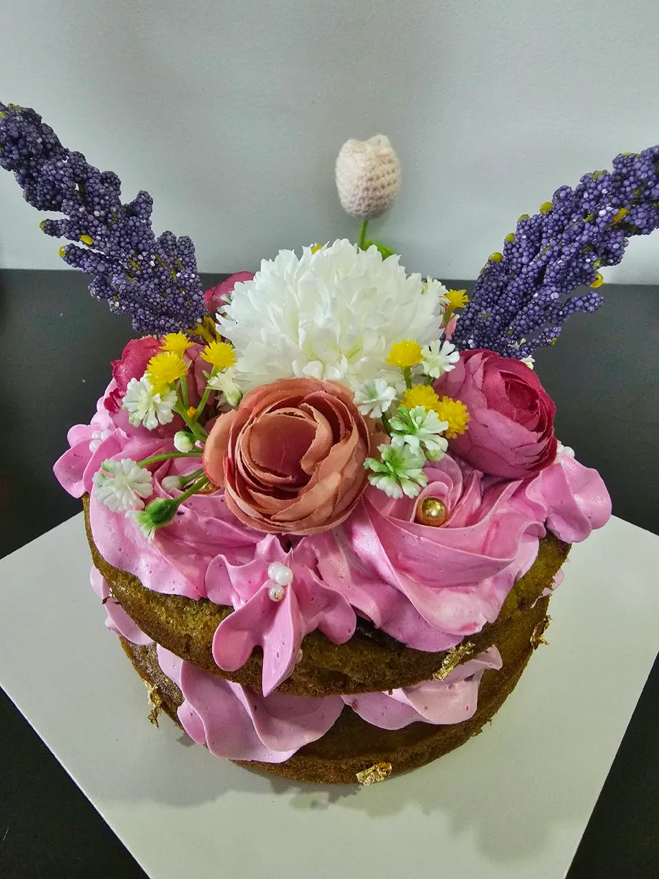 Handmade pink and lavender floral cake adorned with detailed buttercream roses