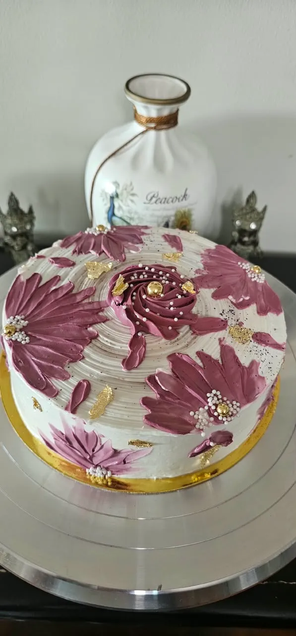 Ivory cake decorated with handcrafted mauve buttercream flowers